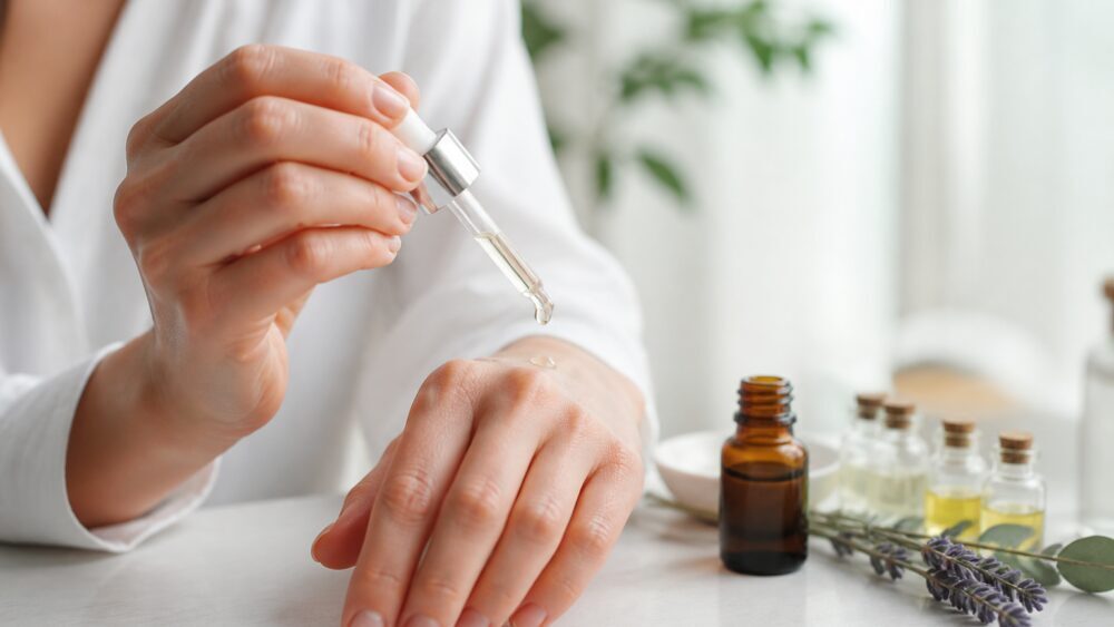 پزشک در حال بررسی قرمزی و تحریک پوست دست بیمار پیش از مصرف روغن های ضروری